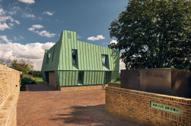 Adrian James Architects completes zero-carbon home with a copper carapace and origami-like appearance