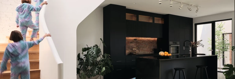Contrasting black kitchen and smooth white staircade